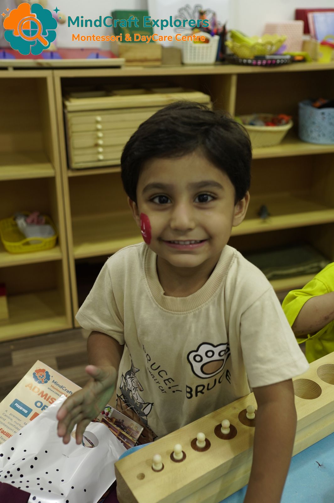 A smiling boy working with the knobbed cylinders